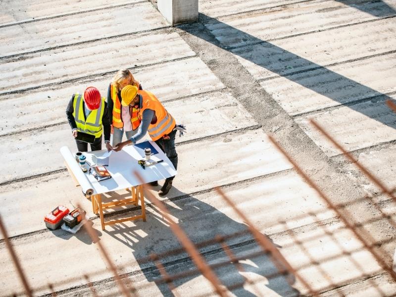 Engineers reviewing construction plans on a commercial development site, illustrating how site design features support daily operations and long-term functionality.
