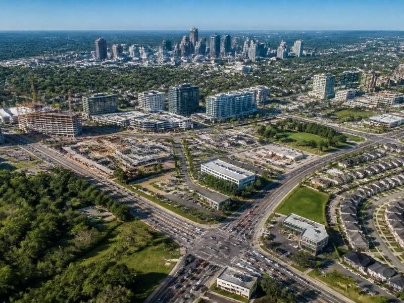 Aerial view of expanding neighborhoods, active development, major roads, and the Raleigh skyline.