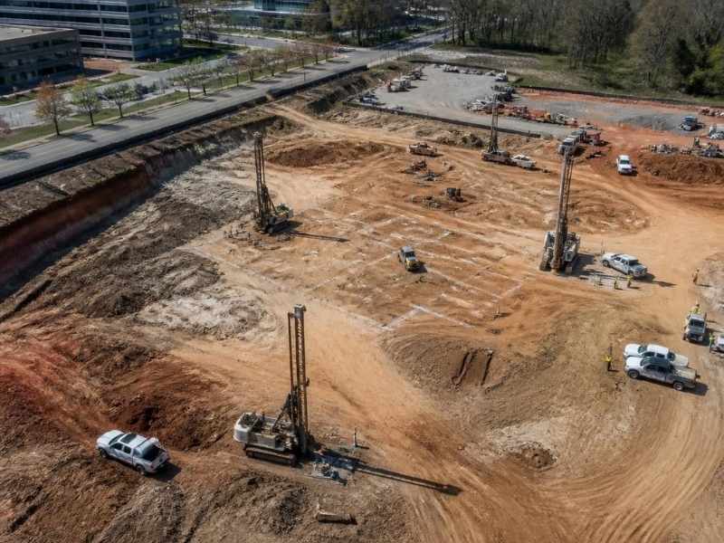 Aerial view of a Raleigh North Carolina construction site showing geotechnical drilling equipment, soil testing areas and ground investigation work before building design.
